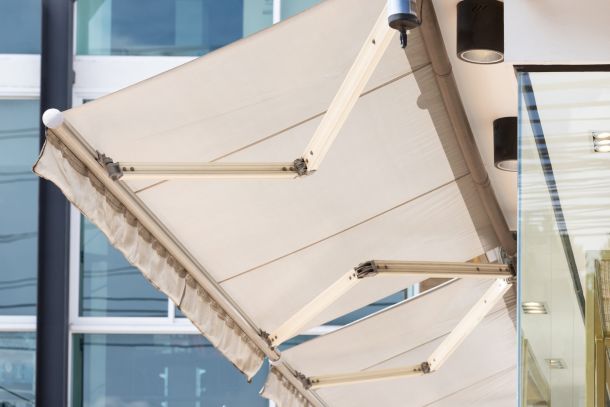 Tenda da sole bianca e struttura in acciaio del negozio.