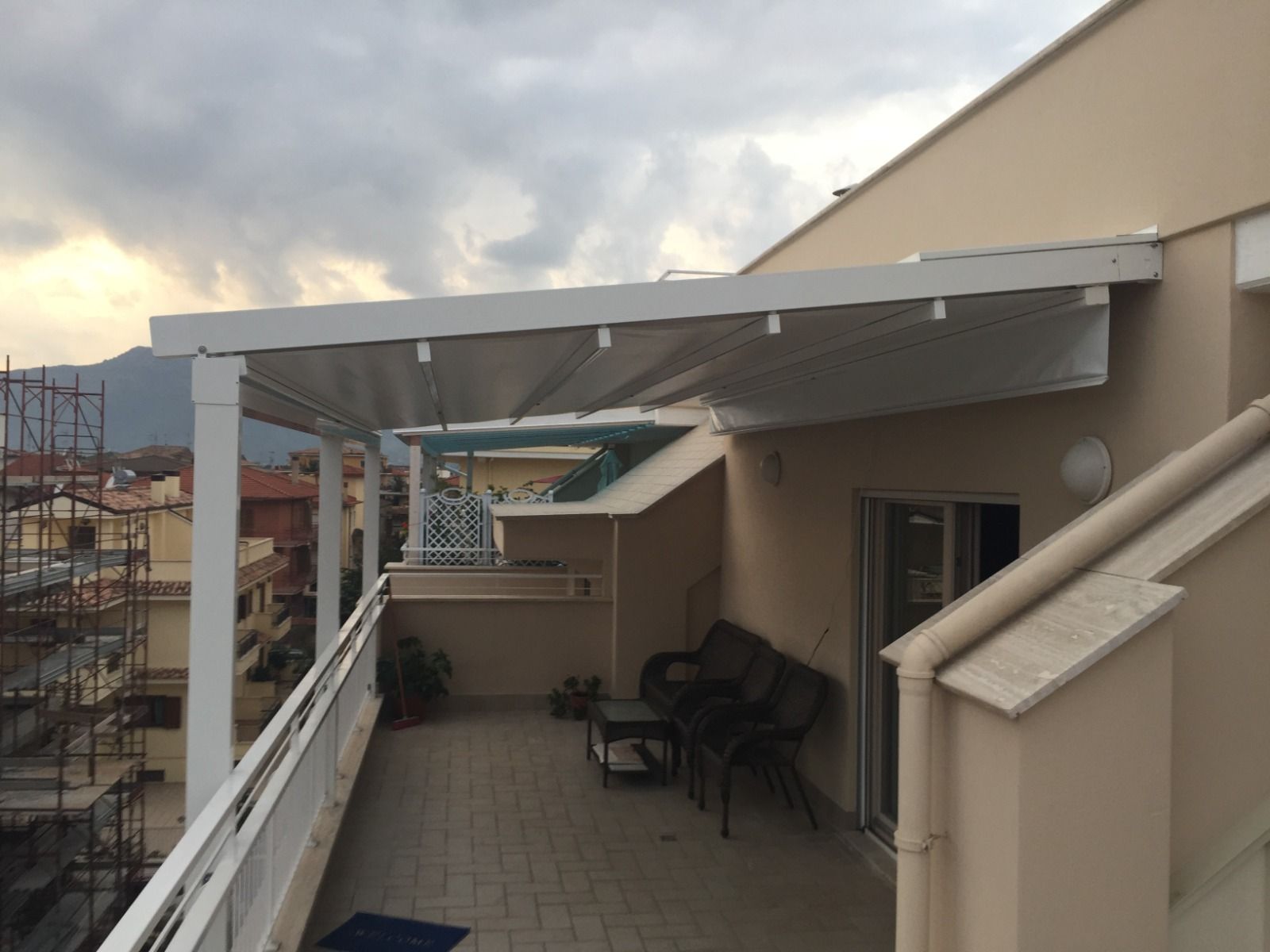 Una tenda bianca installata sul balcone con vista sulla città.
