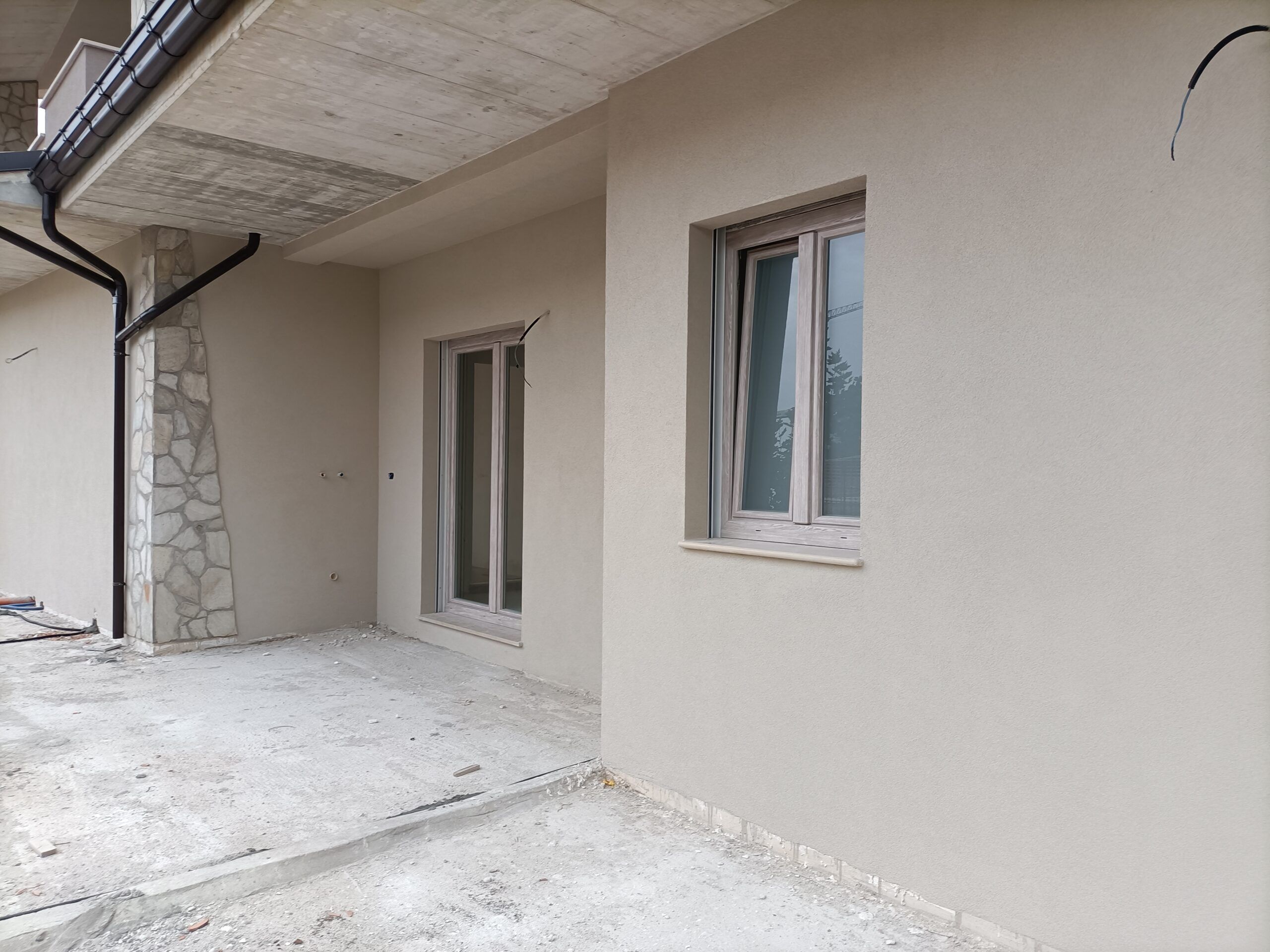 Abitazione colore beige con piccola finestra e porta.