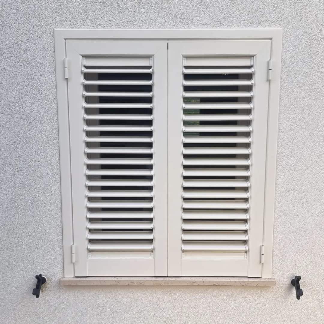 Primo piano della persiana bianca sulla parete dello stesso colore